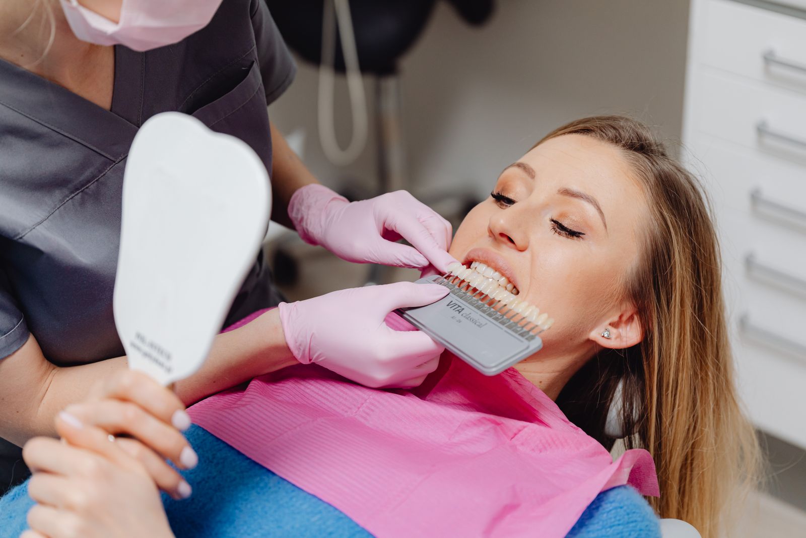 A dentist matching tooth color with a shade guide