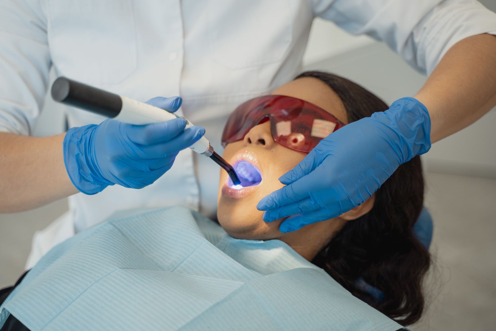 A dentist using a curing light during a bonding treatment